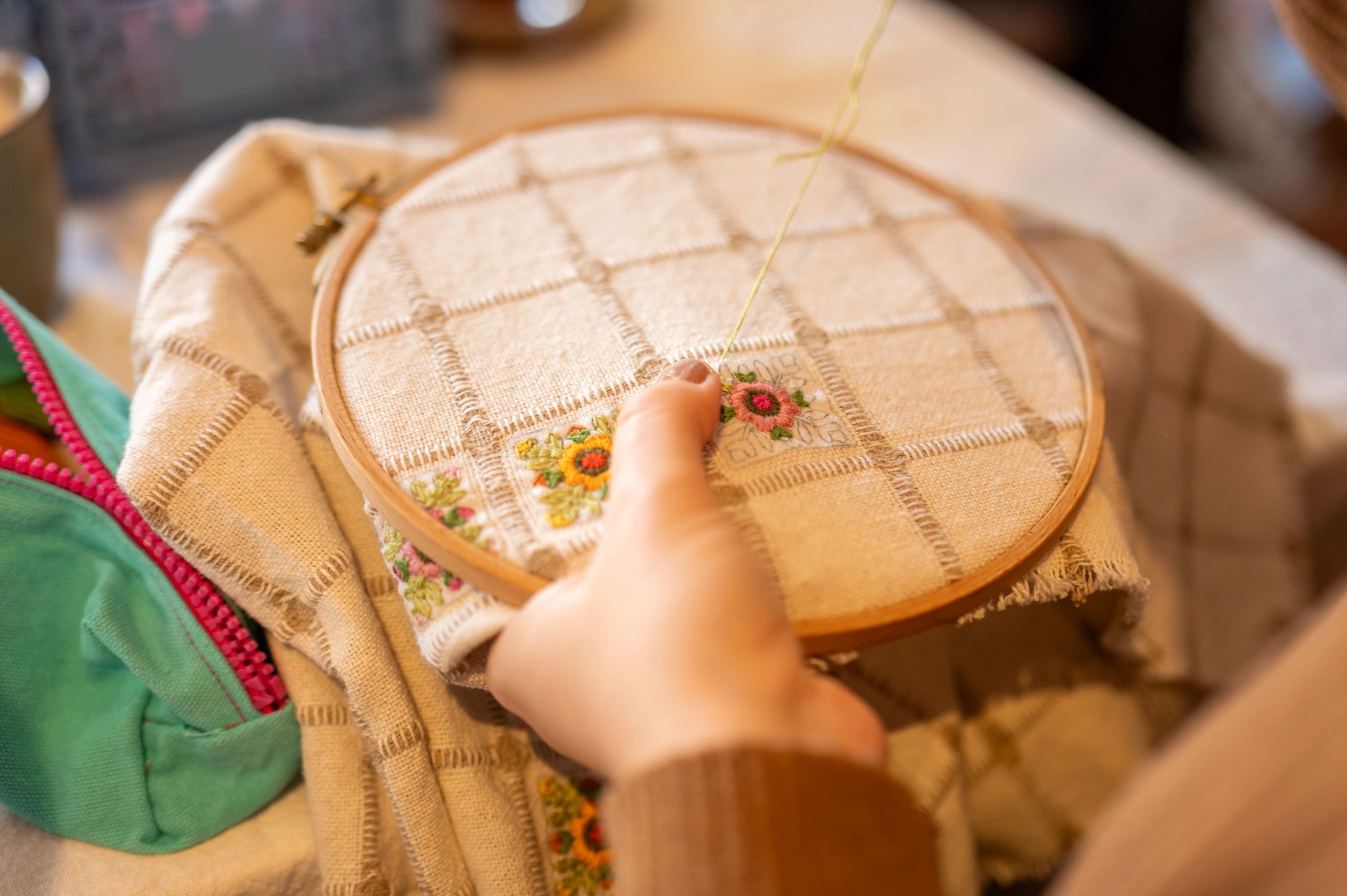 Hand stitching a colorful embroidered design in a hoop